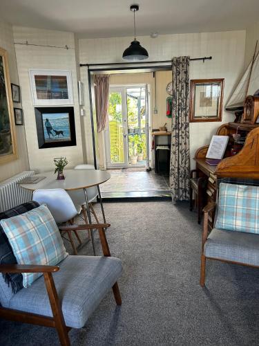 a living room with a table and chairs and a piano at Number 28a in Exmouth