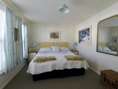 a bedroom with a bed and a large mirror at Number 28a in Exmouth