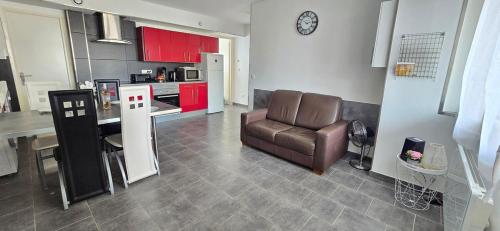 un salon avec un canapé et une cuisine dans l'établissement Nid de vacances à Valras - Clim et proche plage, à Valras-Plage
