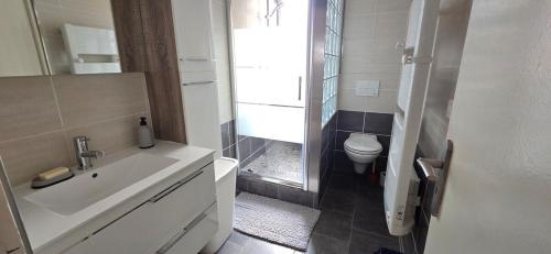 une salle de bain blanche avec un lavabo et des toilettes dans l'établissement Nid de vacances à Valras - Clim et proche plage, à Valras-Plage