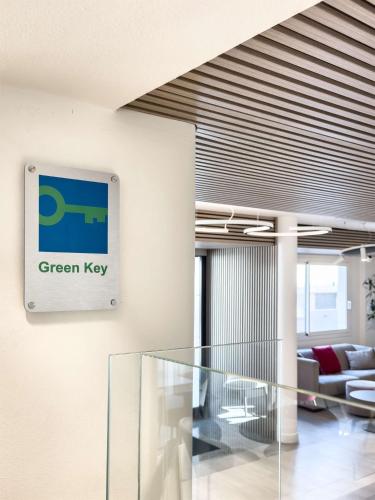 an office lobby with a green key sign on the wall at Best Western Hotel Residence Italia in Quartu SantʼElena