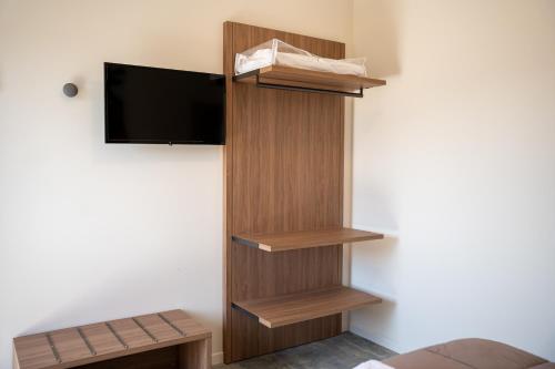 a room with wooden shelves and a flat screen tv at roveleto camere in Roveleto