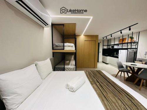 a bedroom with a white bed and a table at Edifício Box 150 - LikeHome Hospedagens in João Pessoa