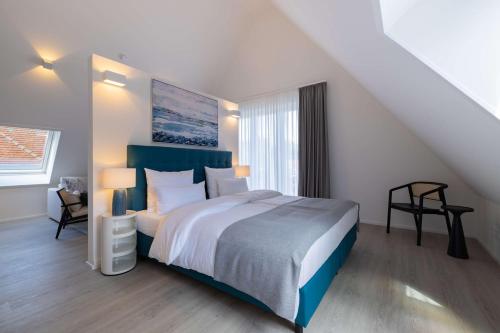 a bedroom with a large bed and a staircase at ATLANTIC Grand Hotel Travemünde in Travemünde