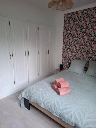 - une chambre avec un lit et 2 serviettes roses dans l'établissement Appartement, à Guingamp