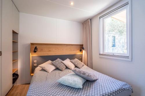 ヴァンドルにあるCamping Domaine de la Yoleのベッドルーム1室(枕付きのベッド1台、窓付)