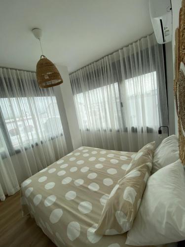 a bedroom with a bed and two large windows at Casa Mateo in Jedula