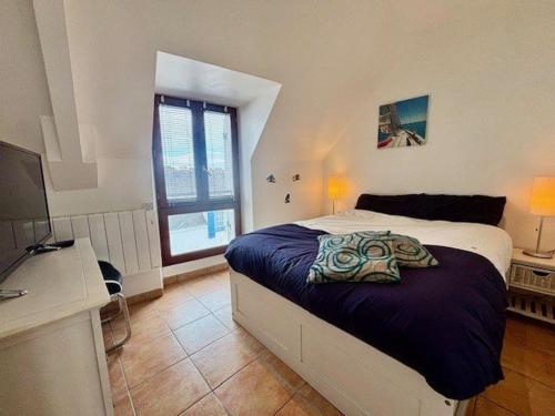 une chambre avec un lit, un bureau et une télévision dans l'établissement Quiberon : T3 ensoleillé proche plage, 3 pièces, 2 chambres - FR-1-478-313, à Quiberon