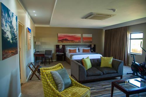 a hotel room with a bed and a couch at Cresta Mahalapye Hotel in Mahalapye