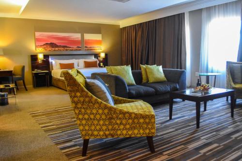 a hotel room with a bed and a couch at Cresta Mahalapye Hotel in Mahalapye