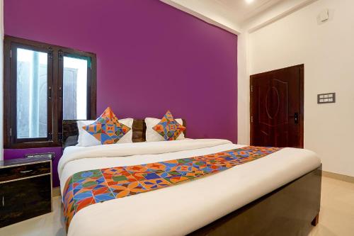 a bedroom with a large bed with a purple wall at Via Awadh Royal in Ayodhya