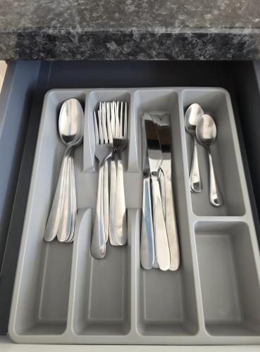 a tray with silver utensils on a counter at Cozy flat & Lovely garden, High Speed WiFi in Cranford