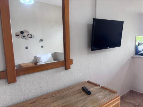 una camera con specchio e TV a parete di ALEKA Kos City Center Apartments a Città di Kos