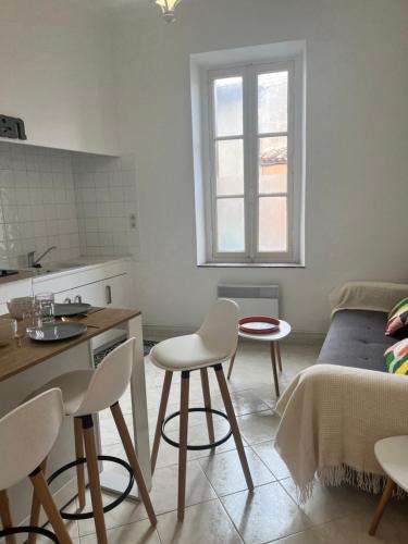 une cuisine avec une table et des chaises dans une pièce dans l'établissement Aux 138 bis, à Carcassonne