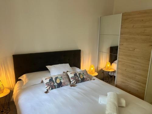 une chambre avec un grand lit blanc avec deux lampes dans l'établissement Aux 138 bis, à Carcassonne