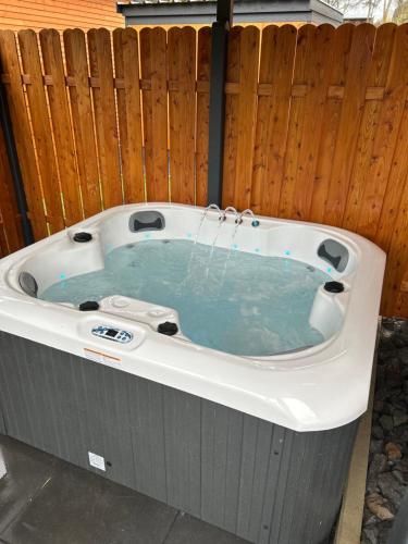 a jacuzzi tub in a backyard with a fence at Urlaub am Schwarzbach mit Sauna und Whirlpool Haus Johanna in Butgenbach