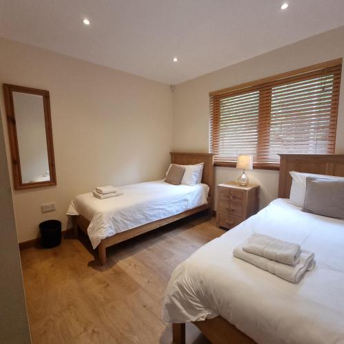 a bedroom with two beds and a mirror at Cairngorm Lodges in Aboyne
