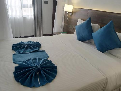 a large bed with two blue pillows on it at Lukenya Alkebu Resort in Nairobi