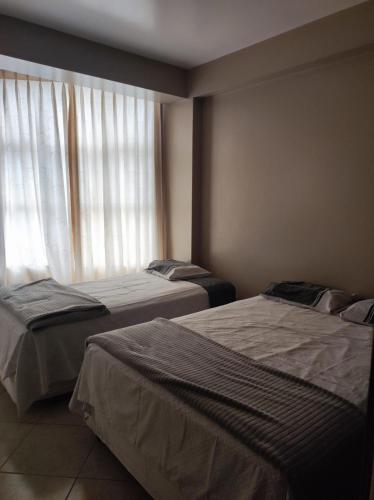 two beds in a room with a window at Borsalino Hostal in Rioja