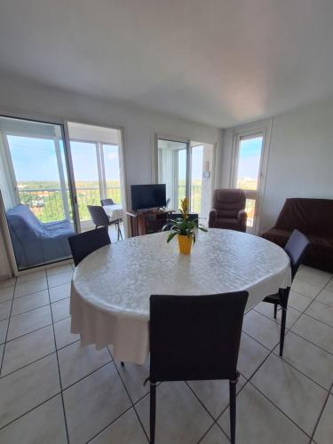 un salon avec une table et des chaises blanches dans l'établissement Les pieds dans l'eau, à Argelès-sur-Mer