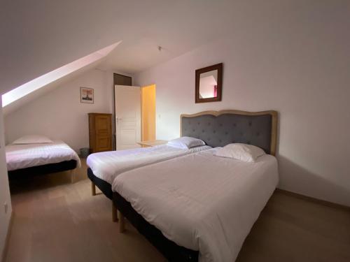 - une chambre avec 2 lits et un escalier dans l'établissement Maison des Cordeliers, à Bayeux