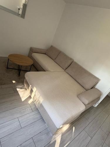 un canapé dans un salon avec une table dans l'établissement Appartement parking proche Dijon centre, à Longvic