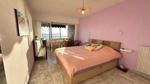 une chambre avec un lit avec un mur rose dans l'établissement Paradou on the beach, amazing view, 3 beds, à Antibes