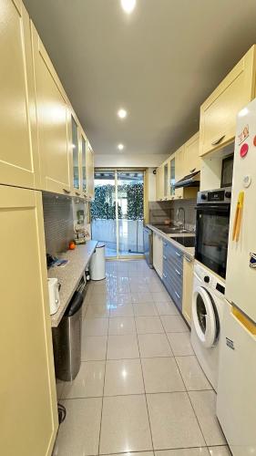 une grande cuisine avec des armoires et des appareils blancs dans l'établissement Paradou on the beach, amazing view, 3 beds, à Antibes