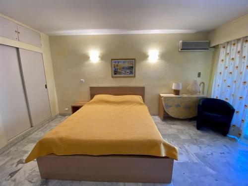 une chambre avec un lit, un bureau et une chaise dans l'établissement Cannes proche Croisette - Studio, à Cannes