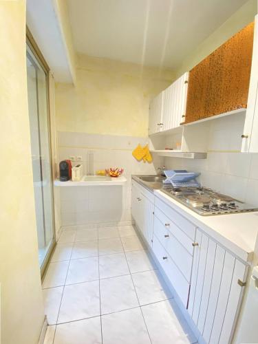 une cuisine avec des armoires blanches et une cuisinière dans l'établissement Cannes proche Croisette - Studio, à Cannes