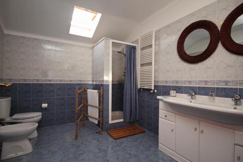 uma casa de banho com um lavatório, um WC e um espelho. em Quinta Beira-Mar em Sintra