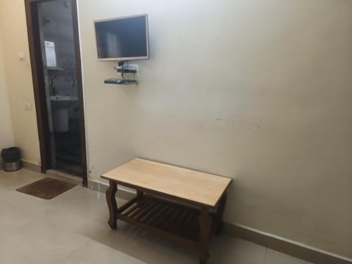 AnakāpalleにあるRamnivas Accommodationsの壁にテレビが付いた部屋の木製テーブル