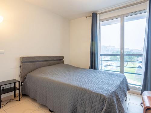 une chambre avec un lit et une grande fenêtre dans l'établissement Apartment Blue Bay-1 by Interhome, à Deauville