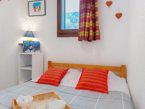 une chambre avec un lit avec deux oreillers rouges dessus dans l'établissement Apartment Les Hauts de Saint Gervais-3 by Interhome, à Saint-Gervais-les-Bains