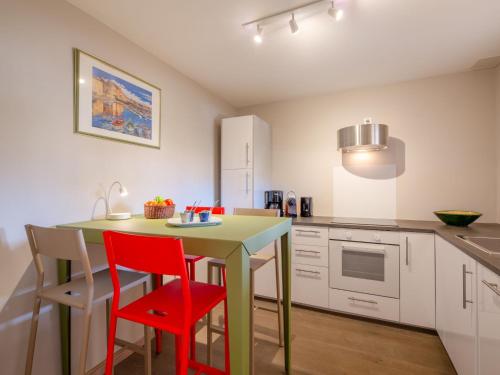 une cuisine avec une table verte et des chaises rouges dans l'établissement Apartment Clos Etienne by Interhome, à Sainte-Maxime