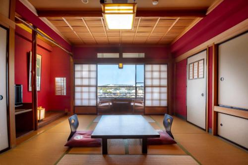 a dining room with a table and chairs in a room at Yuyaruru Saisai in Kanazawa