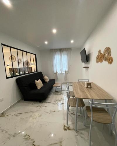 un salon avec un canapé noir et une table dans l'établissement Appartement T2 proche de la gare, à Arles