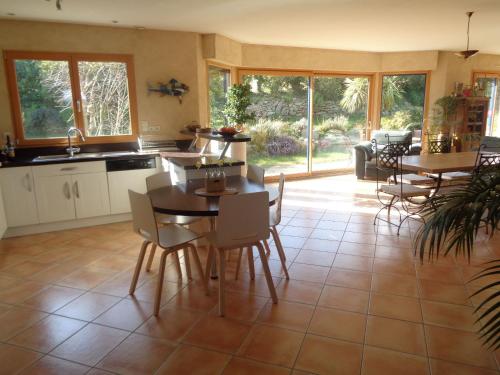 une cuisine et une salle à manger avec une table et des chaises dans l'établissement Séjour détente en famille à deux pas de la plage, à Saint-Pol-de-Léon
