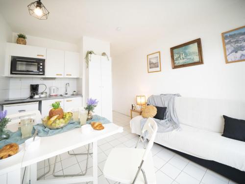 - un salon blanc avec une table et des fruits dans l'établissement Apartment Port Athéna by Interhome, à La Grande Motte