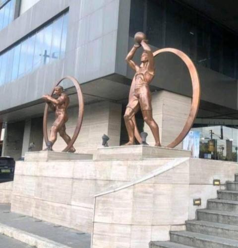a statue of two men playing hoops in front of a building at Quezon City Apartment 2 Condo-Hotel with Pool View in Manila