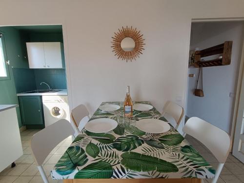 une table à manger avec un tissu de table vert et blanc dans l'établissement Apartment Résidence Les Sangliers by Interhome, à Saint-Raphaël
