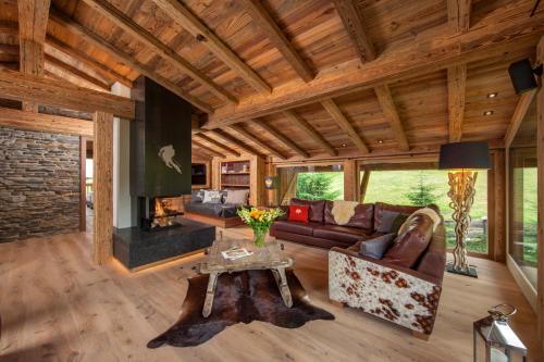 a living room with a couch and a fireplace at Chalet Katharina in Kirchberg in Tirol