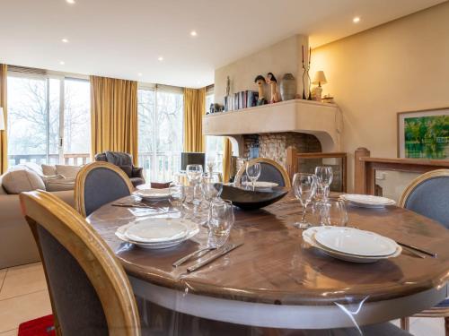 une salle à manger avec une table et des chaises et une cheminée dans l'établissement Apartment Les Hauts de Deauville-2 by Interhome, à Tourgéville