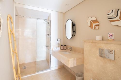 a bathroom with a shower and a sink and a mirror at El Gouna - BIRD NEST in Hurghada