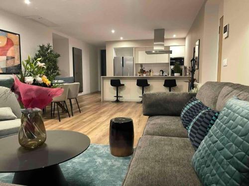 a living room with a couch and a table and a kitchen at Oceanfront Elegance Madeira Retreat in Câmara de Lobos