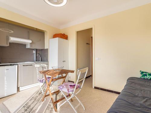 une petite cuisine avec une table et des chaises dans une pièce dans l'établissement Studio Le Grand Large-4 by Interhome, au Lavandou
