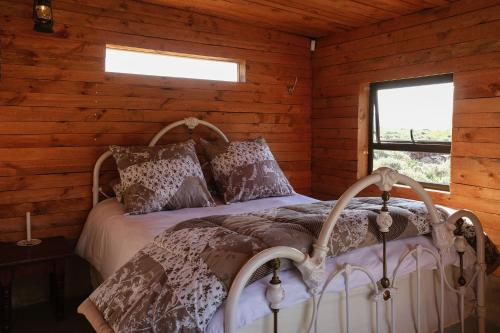 a bedroom with a bed in a log cabin at Ida Olive Shepherd's Cottage in McGregor