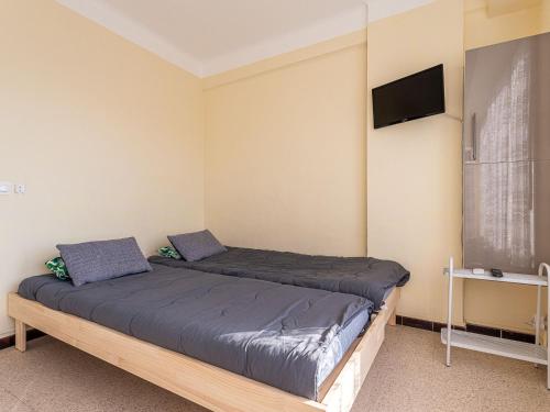 une chambre avec deux lits et une télévision à écran plat dans l'établissement Studio Le Grand Large-4 by Interhome, au Lavandou