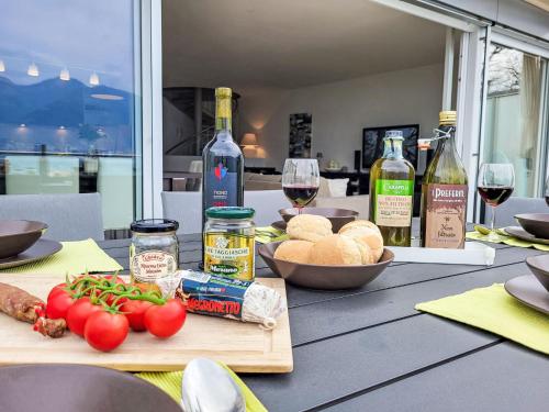 a table with a cutting board with vegetables and wine bottles at Apartment Splendid Maggiore View by Interhome in Magadino