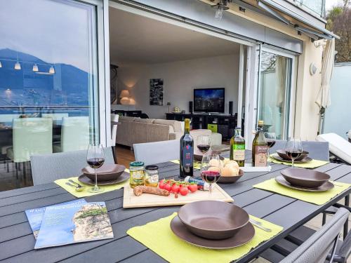 a table with glasses of wine and food on it at Apartment Splendid Maggiore View by Interhome in Magadino